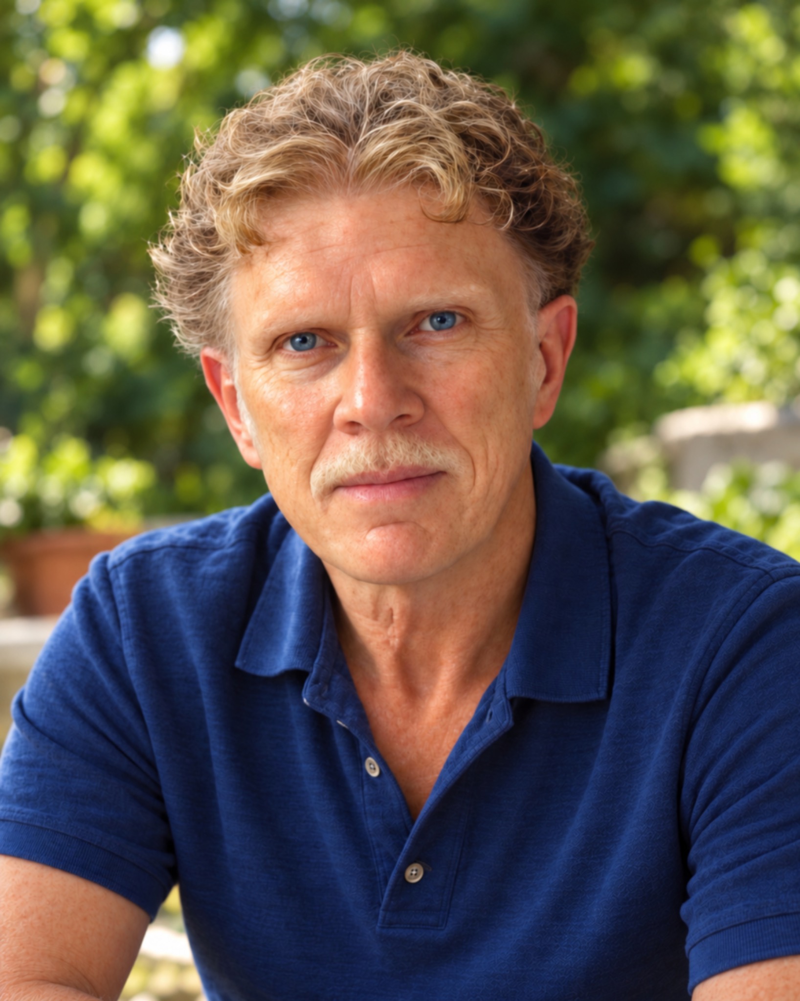 Author Michael Cassimaty in a blue polo shirt outdoors